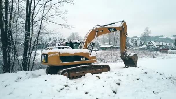 BIALKA TATRZANSKA, POLOGNE - 3 FÉVRIER 2018. Vue aérienne d'une excavatrice sur chenilles Caterpillar CAT dans la neige — Video