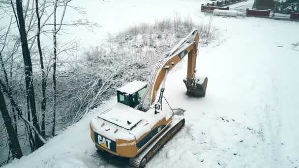 タトシャンスカ ビャウカ, ポーランド - 2018 年 2 月 3 日。雪の中でのキャタピラー猫クローラー掘削機の空撮 — ストック動画