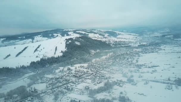 Luftaufnahme von Bialka Tatrzanska Dorf, das berühmte Skigebiet an einem nebligen Wintertag. Südpolen, die Tatra — Stockvideo