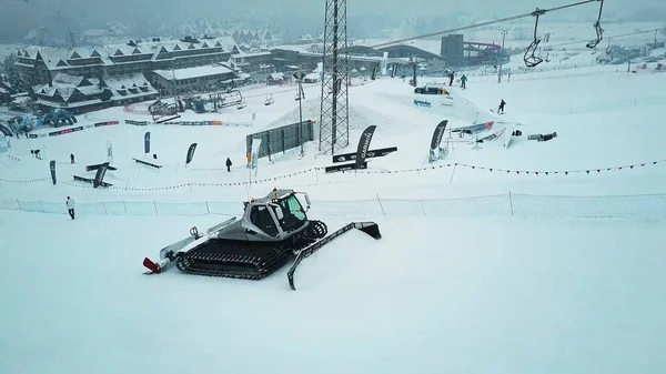 BIALKA TATRZANSKA, POLÓNIA - FEVEREIRO 3, 2018. Vista aérea de um snowcat ou groomer da neve em uma inclinação da estância de esqui no inverno — Fotografia de Stock