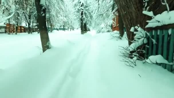 POV chůze po zasněžené silnici v ruské vesnici po husté sněžení — Stock video