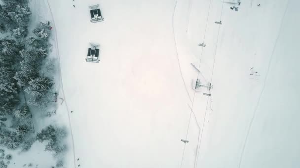 Antenne boven naar beneden van de weergave van een snowcats of sneeuw trimmers op een helling resort ski in de winter — Stockvideo