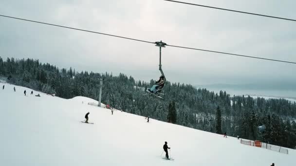 Luchtfoto van onherkenbaar mensen op een berghelling van de ski — Stockvideo