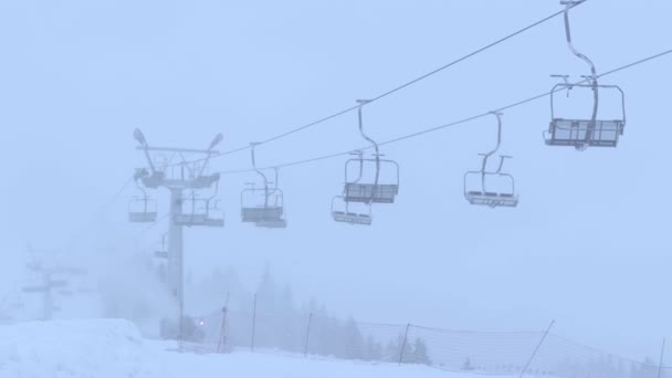 Pista de esquí de montaña y telesilla vacía en funcionamiento en la niebla — Vídeos de Stock