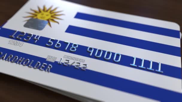 Plastic bank card featuring flag of Uruguay. National banking system related animation — Stock Video