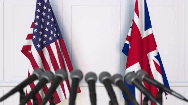 国際会議や交渉の記者会見で、アメリカとイギリスの国旗 — ストック動画