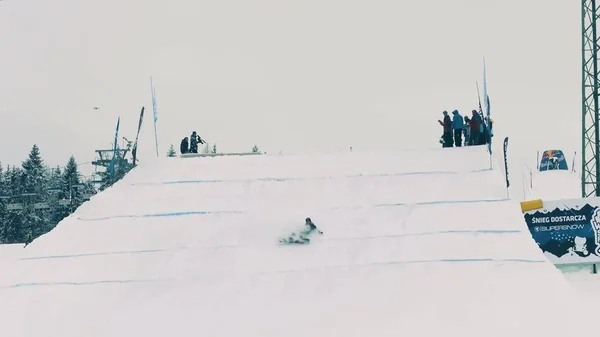 BIALKA TATRZANSKA, POLÓNIA - FEVEREIRO 3, 2018. Snowboard freestyle rider falhando em executar um truque no trampolim — Fotografia de Stock