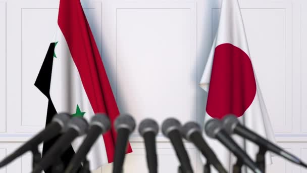 Flags of Syria and Japan at international meeting or negotiations press conference — Stock Video