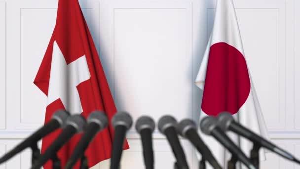 Banderas de Suiza y Japón en la reunión internacional o en la conferencia de prensa de negociaciones — Vídeo de stock