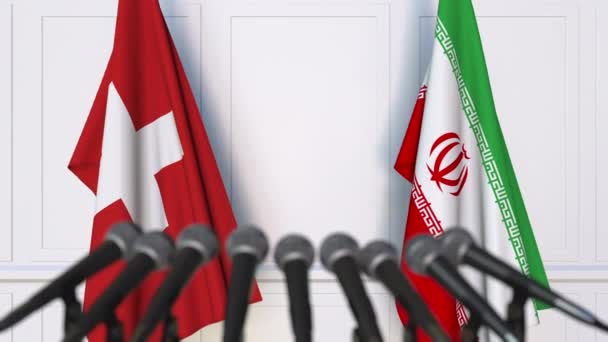 Flags of Switzerland and Iran at international meeting or negotiations press conference — Stock Video