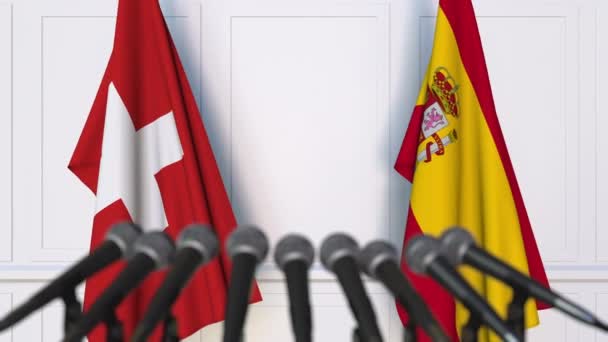 Flags of Switzerland and Spain at international meeting or negotiations press conference — Stock Video