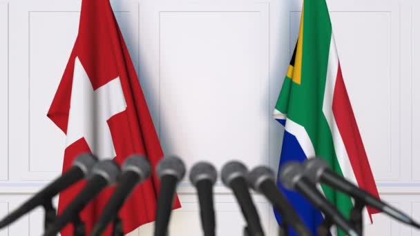 Flags of Switzerland and South Africa at international meeting or negotiations press conference — Stock Video