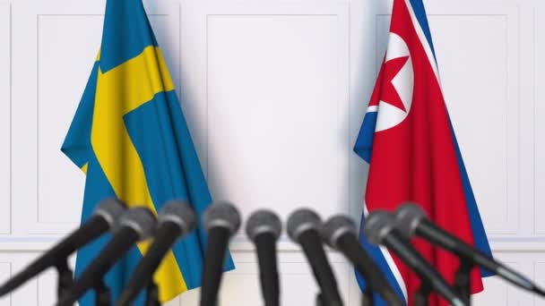 Flaggor i Sverige och Nordkorea vid internationella förhandlingar eller möte presskonferens — Stockvideo