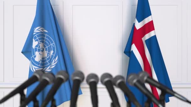 Флаги ООН и Исландии на международной встрече или пресс-конференции — стоковое видео
