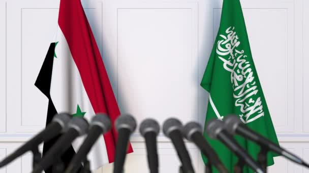 Bandeiras da Síria e Arábia Saudita em reunião internacional ou negociações conferência de imprensa — Vídeo de Stock