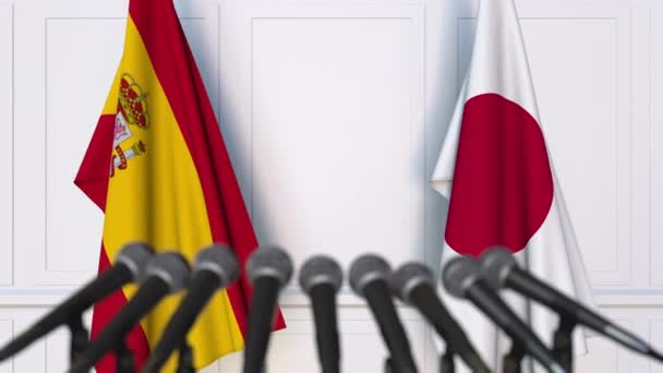 Flags of Spain and Japan at international meeting or negotiations press conference — Stock Video
