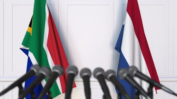 Banderas de Sudáfrica y los Países Bajos en la reunión internacional o en la conferencia de prensa de negociaciones — Vídeo de stock