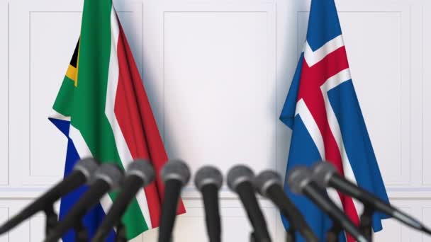 Flaggen von Südafrika und Island bei internationalen Treffen oder Verhandlungen Pressekonferenz — Stockvideo