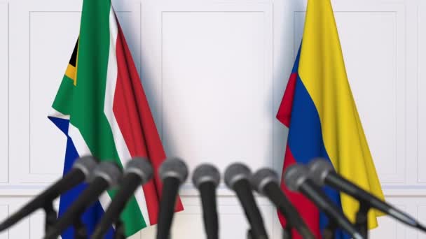 Banderas de Sudáfrica y Colombia en reunión internacional o en conferencia de prensa de negociaciones — Vídeo de stock