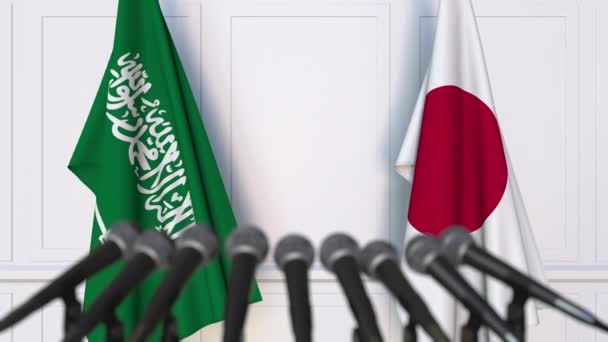Bandeiras da Arábia Saudita e do Japão em reunião internacional ou negociações conferência de imprensa — Vídeo de Stock