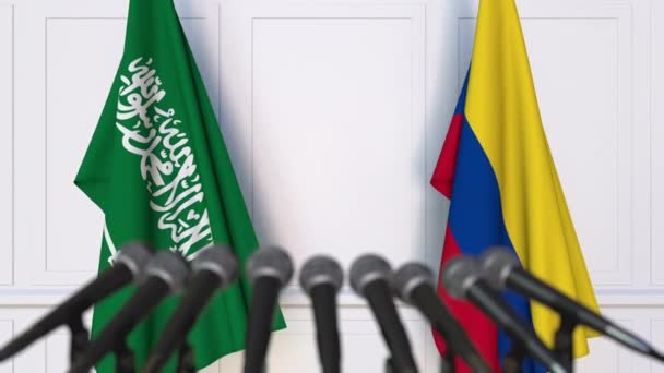Banderas de Arabia Saudita y Colombia en reunión internacional o conferencia de prensa de negociaciones — Vídeos de Stock