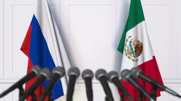 Флаги России и Мексики на международной встрече или пресс-конференции — стоковое видео