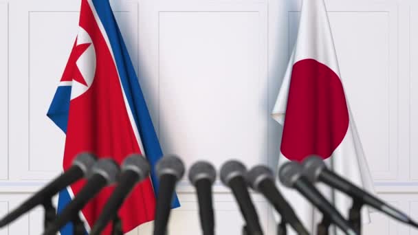 Vlajky Severní Koreje a Japonska na mezinárodní tiskové konferenci zasedání nebo jednání — Stock video