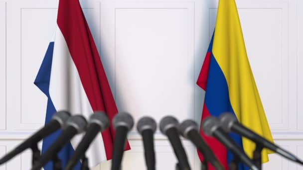 Flaggen der Niederlande und Kolumbiens bei internationalen Treffen oder Verhandlungen Pressekonferenz — Stockvideo