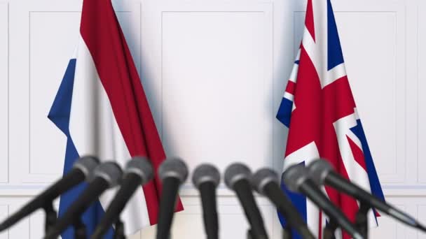 Σημαίες των κάτω χωρών και του Ηνωμένου Βασιλείου σε διεθνή διάσκεψη τύπου συνάντησης ή διαπραγματεύσεις — Αρχείο Βίντεο