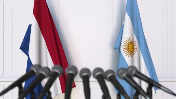 Bandeiras dos Países Baixos e da Argentina em reunião internacional ou negociações conferência de imprensa — Vídeo de Stock