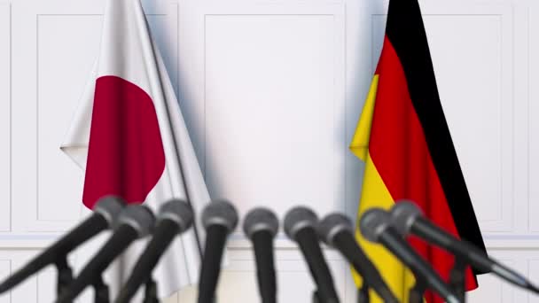 Flagi, Japonia i Niemcy, na międzynarodowej konferencji prasowej spotkania lub negocjacji — Wideo stockowe