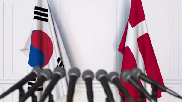 Banderas de Corea del Sur y Dinamarca en reunión internacional o en conferencia de prensa de negociaciones — Vídeo de stock