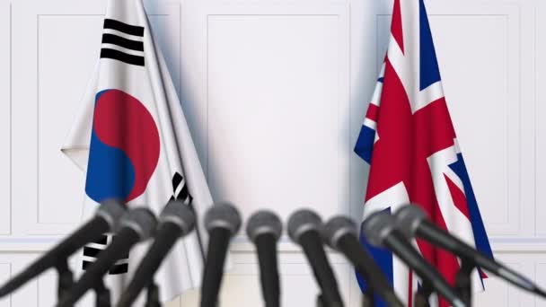 Banderas de Corea del Sur y el Reino Unido en la reunión internacional o en la conferencia de prensa de negociaciones — Vídeo de stock