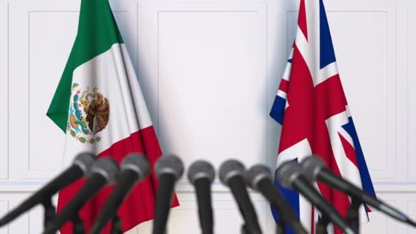 Banderas de México y el Reino Unido en reunión internacional o en conferencia de prensa de negociaciones — Vídeo de stock