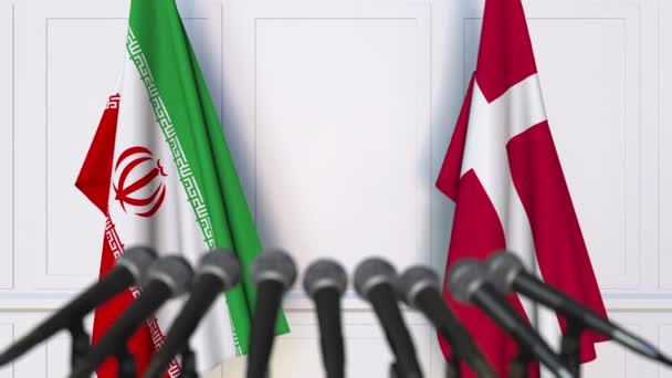 Флаги Ирана и Дании на международной встрече или пресс-конференции — стоковое видео
