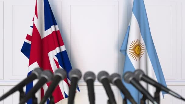 国際会議や交渉の記者会見で、イギリスとアルゼンチンの国旗 — ストック動画