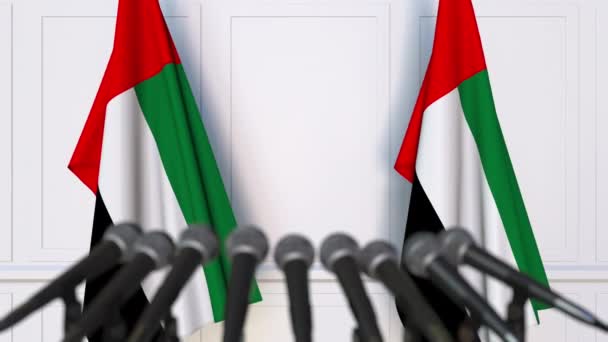 Offizielle Pressekonferenz. Flaggen der Vereinigten Arabischen Emirate und Mikrofone. Konzeptionelle Animation — Stockvideo