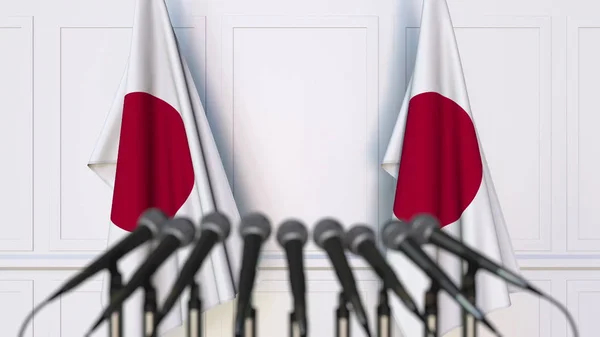 Japanska officiella presskonferens. Flaggor av Japan och mikrofoner. Konceptuell 3d-rendering — Stockfoto