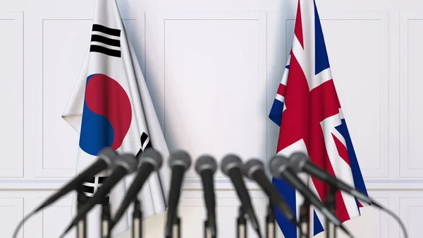 Flaggor av Sydkorea och Storbritannien på internationellt möte eller konferens. 3D-rendering — Stockfoto