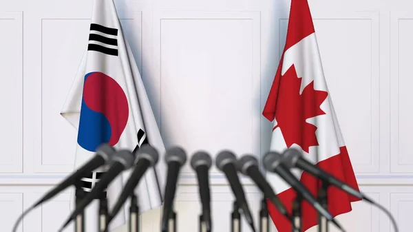 Bandeiras da Coreia do Sul e Canadá em reunião ou conferência internacional. Renderização 3D — Fotografia de Stock