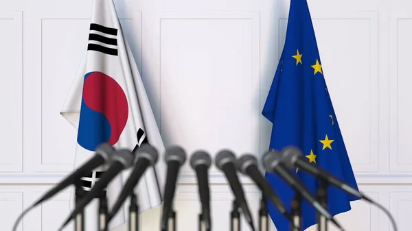Bandeiras da Coreia do Sul e da União Europeia em reunião ou conferência internacional. Renderização 3D — Fotografia de Stock