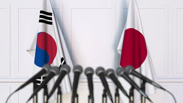 Bandeiras da Coreia do Sul e Japão em reunião ou conferência internacional. Renderização 3D — Fotografia de Stock
