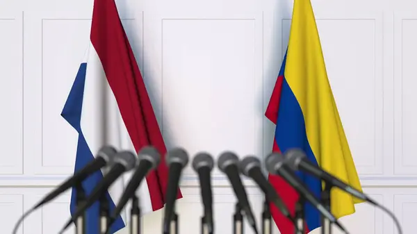 Bandiere dei Paesi Bassi e della Colombia in occasione di riunioni o conferenze internazionali. Rendering 3D — Foto Stock