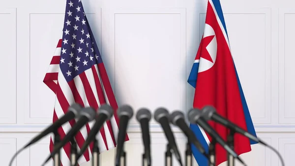 Banderas de los Estados Unidos y Corea del Norte en una reunión o conferencia internacional. Renderizado 3D — Foto de Stock