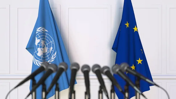 Drapeaux des Nations unies et de l'Union européenne lors d'une réunion ou d'une conférence internationale. Editorial rendu 3D — Photo