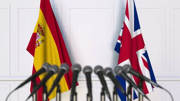 Bandeiras da Espanha e do Reino Unido em reunião ou conferência internacional. Renderização 3D — Fotografia de Stock