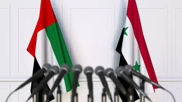 Drapeaux des Émirats arabes unis et de la Syrie lors d'une réunion ou conférence internationale. rendu 3D — Photo