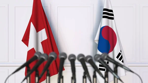 Flaggen der Schweiz und Koreas bei internationalen Treffen oder Konferenzen. 3D-Darstellung — Stockfoto