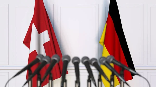 Bandeiras da Suíça e da Alemanha em reunião ou conferência internacional. Renderização 3D — Fotografia de Stock