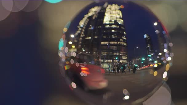 Centrum wegverkeer en de mensen het oversteken van de straat in de avond, bekijken door de glazen bal — Stockvideo